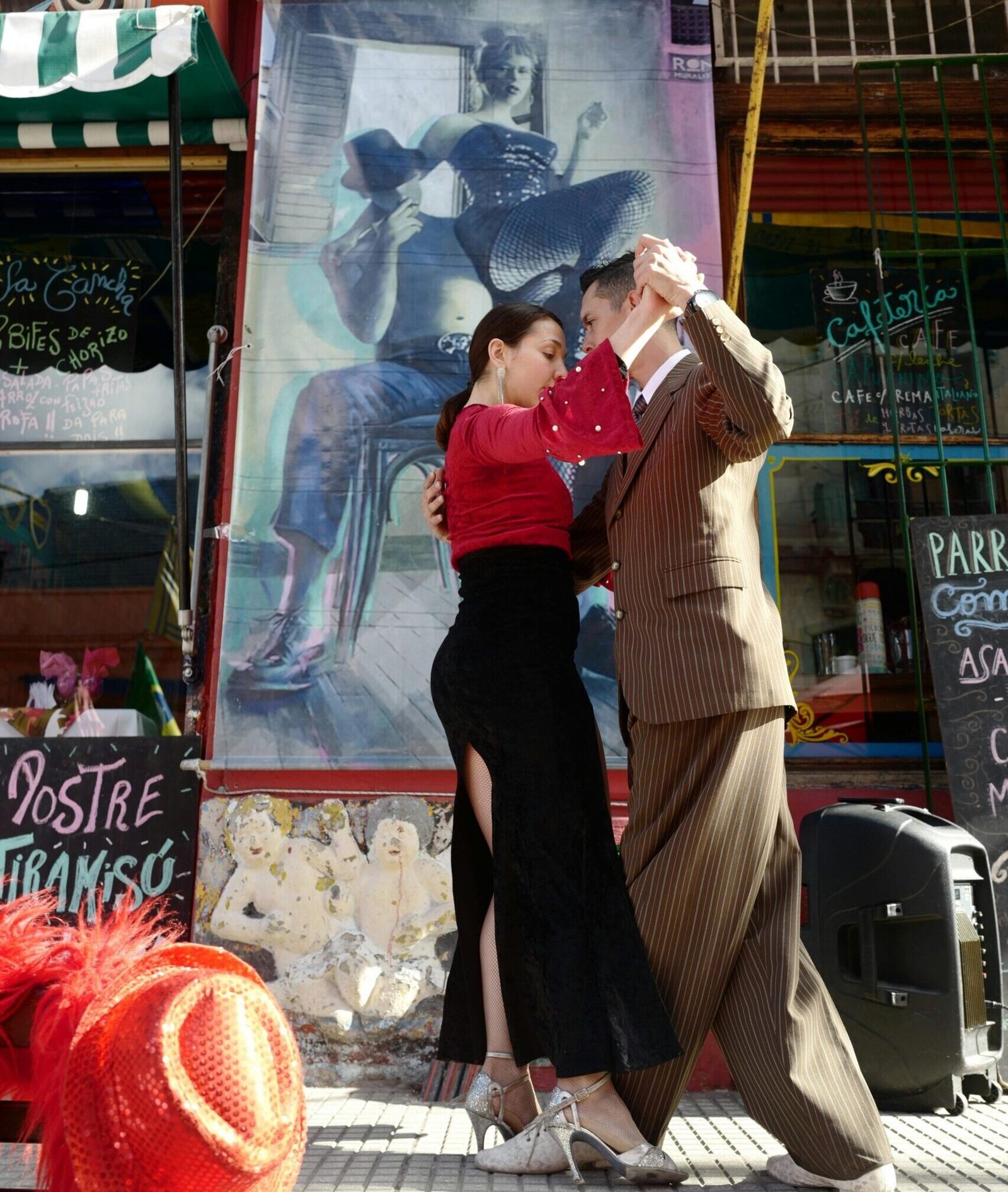 A couple performs an elegant tango dance on a vibrant street in Buenos Aires.